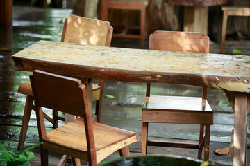 Fototapeta na wymiar Rain drops on old wooden chairs, rain with old wooden chairs, wooden benches and nature