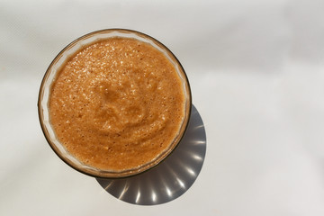 plate of apple, pear and banana smoothie on a white tablecloth. Detox, diet, healthy, vegetarian food concept with copy space, view from above.