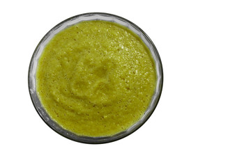 Healthy green smoothie with spinach, banana, kiwi, broccoli and apple in glass bowl isolated on the white background.