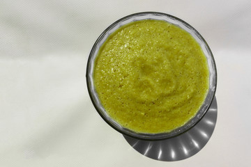 Healthy apple banana smoothie drink in a glass bowl on a white background. Healthy vegetarian breakfast for weight loss.