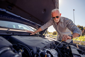 Senior man check oil in car