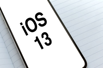 iOS 13 inscription on the white screen of smartphone