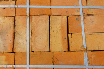 Close up orange bricks on a warehouse, view from above. Packed orange bricks, Building materials stacked into cube, Storage brickwork product.