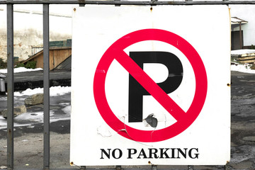 parking is prohibited - deformed and cracked road sign installed on the old fence outdoors