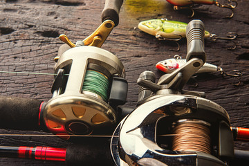 Fishing lures, hooks and accessories on darken wooden background.Top view.