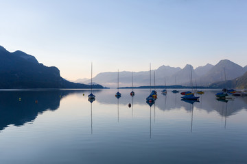 Beautiful scenery during sunrise of Lake Wolfgangsee in Austrian Alps with the sailboats parked on the waterfront. Travel and Attraction Concept