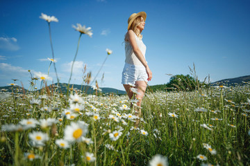 Beautiful woman in the field with flowers. 