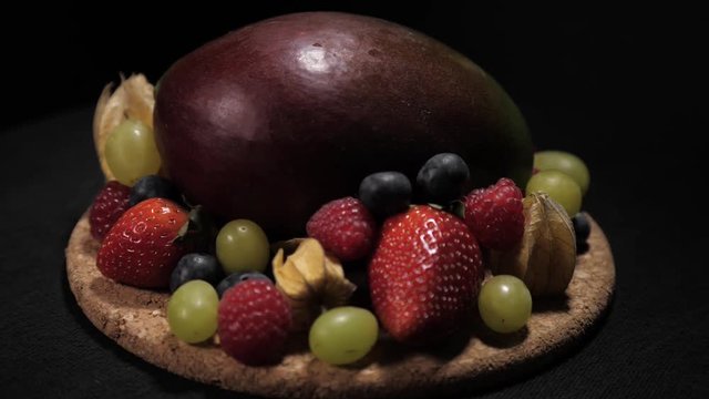Fresh fruit mix on rotating corc plate. Still high perspective medium shot.