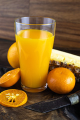 Still life photo of orange juice, orange smoothie in a glass on wooden background.