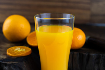 Still life photo of orange juice, orange smoothie in a glass on wooden background.