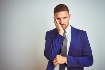 Young handsome business man over white isolated background thinking looking tired and bored with...