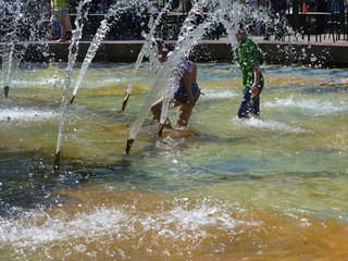 Bathing children on a hot day in the fountain. Hot and high temperature. Weather
