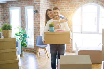 Fototapeta na wymiar Beautiful young couple moving to a new house, smiling happy holding cardboard boxes at new apartment