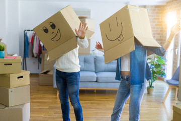 Fototapeta na wymiar Funny couple wearing cardboard boxes with fun crazy emoji faces over head