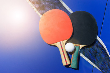 Equipment and accessories for playing ping pong. Rackets, tennis ball, net and table top view. 