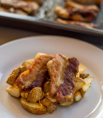 Pork ribs with roasted potatoes and garlic close up