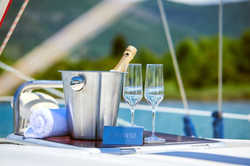 Romantic luxury evening on cruise yacht with champagne setting. Empty glasses and bottle with...
