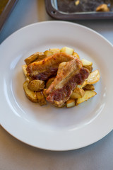 Pork ribs with roasted potatoes and garlic close up