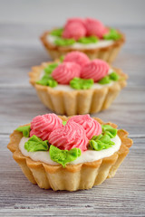 Dessert in the form of cakes with protein cream on wooden background