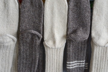 Handmade wool socks hanging for sale on market.