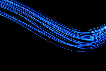 Long exposure, light painting photography.  Vibrant neon electric blue lines of colour against a...
