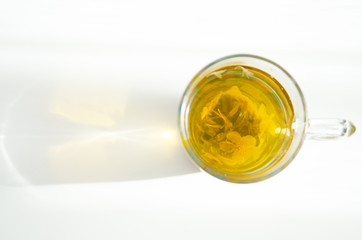 Brewed delicious herbal tea on a wooden white background, shadow and sun rays. - Image