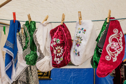 Tatar and Bashkir female traditional vintage hats hang for sale on clothespins on a rope.