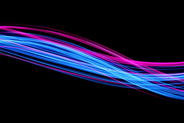 Long exposure, light painting photography.  Vibrant electric blue and neon pink streaks of colour...