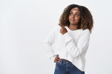 Intrigued pleased good-looking dark-skinned attractive plus-size female model white sweater look...