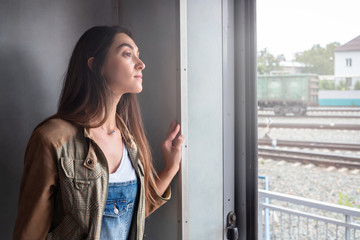 a young girl looks out of the train door. the girl goes on vacation