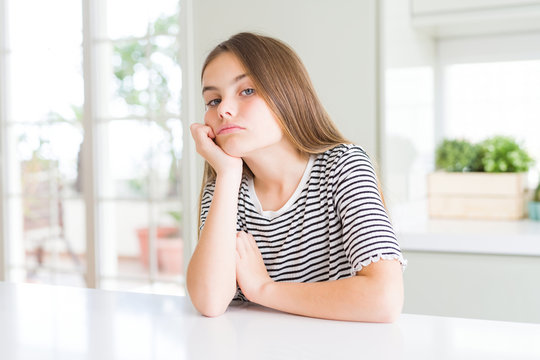 Beautiful young girl kid wearing stripes t-shirt thinking looking tired and bored with depression problems with crossed arms.