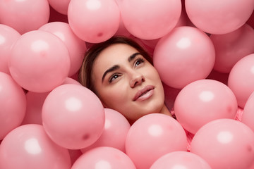 Fototapeta na wymiar Dreamy female lying under balloons
