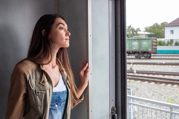 a young girl looks out of the train door. the girl goes on vacation