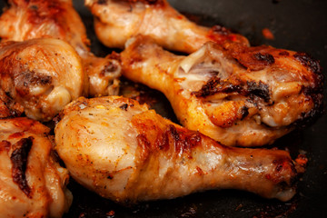 Roasted chicken legs in a black pan