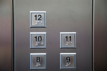 Interior and closeup of metal buttons in elevator.