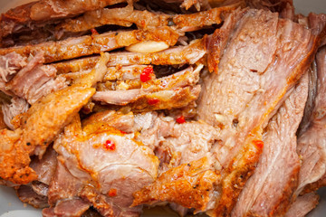 A juicy fresh baked pork with herbs and spice on wooden cutting board.
