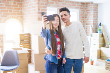 Fototapeta na wymiar Young asian couple smiling taking a selfie photo with smartphone, moving to a new home together