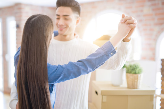 Young Asian Couple Dancing And Smiling Celebrating Moving To A New Home