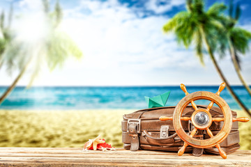 Summer suitcase on beach with palms and landscape of sea and sky. Summer hot day and sun light 