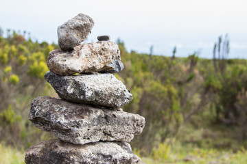 Fototapeta na wymiar Handmade stone pyramid on the mountain trek