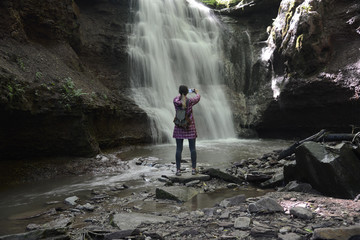 Girl photographs waterfall with phone