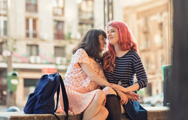 two lesbian girls, couple kiss romantically on the street in the city show love to each other gay pride LGBT pride world movement lesbian, gay, bisexual, transgender proud of their sexual orientation