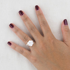 A silver wedding ring on a female hand with red painted nails