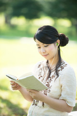 自然の中で読書をする女性