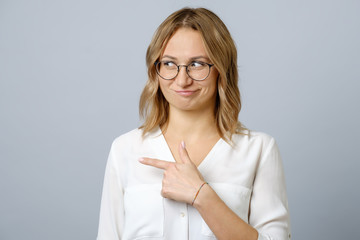 Portrait of a happy young woman pointing fingers away