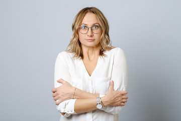 Portrait of a frozen young woman dressed standing isolated