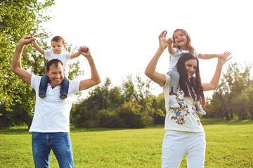 Obraz premium Family with children playing on the grass in the park.