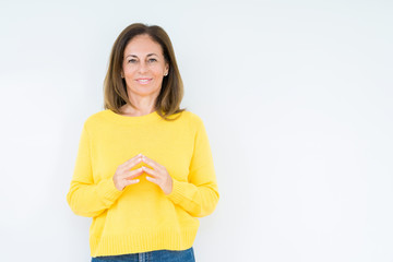 Fototapeta premium Beautiful middle age woman wearing yellow sweater over isolated background Hands together and fingers crossed smiling relaxed and cheerful. Success and optimistic