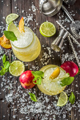 Summer iced peach tea with mint, lime and crushed ice, wooden background copy space