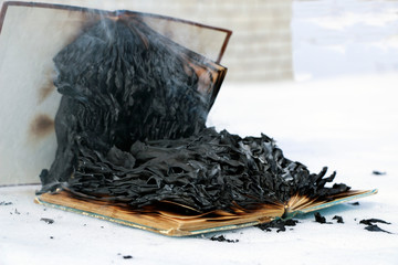 burning book in  snow. pages with the text in  open book burn with  bright flame.